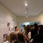 Foto de uma guia da fundação Dorina apresentando a o centro de memória para um grupo de meninas.