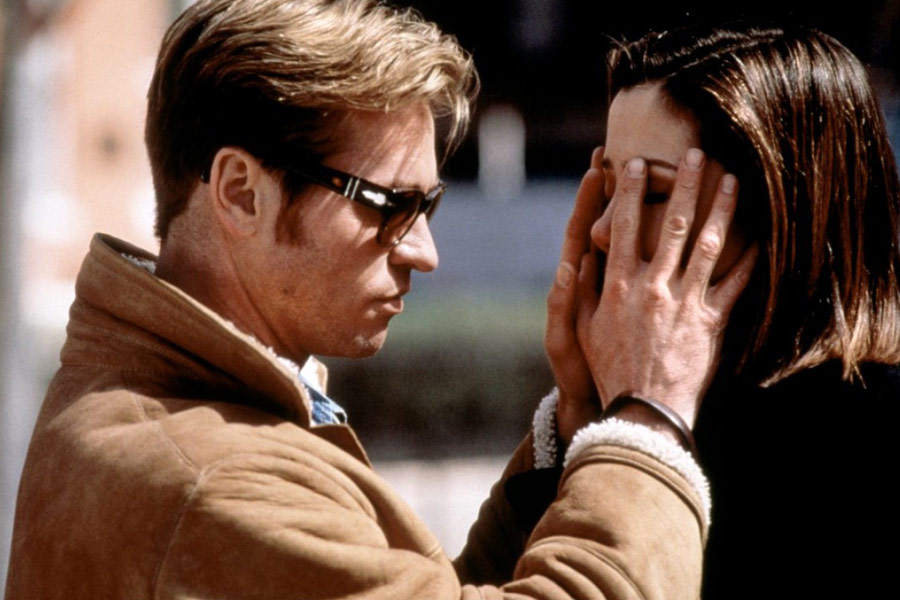 Descrição da imagem: cena do filme À primeira vista. Um homem de óculos escuros toca o rosto de uma moça com as duas mãos. Fim da descrição.