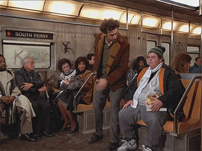 gif animado, com pessoas sentadas dentro de um vagão de metrô. Um homem ocupa dois acentos, enquanto outro está em pé, ao seu lado, empurrando para conseguir sentar. 